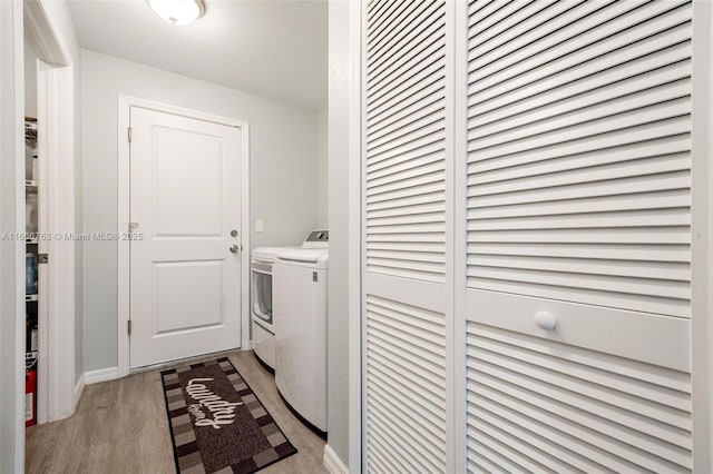 laundry area with washer and dryer and light hardwood / wood-style flooring