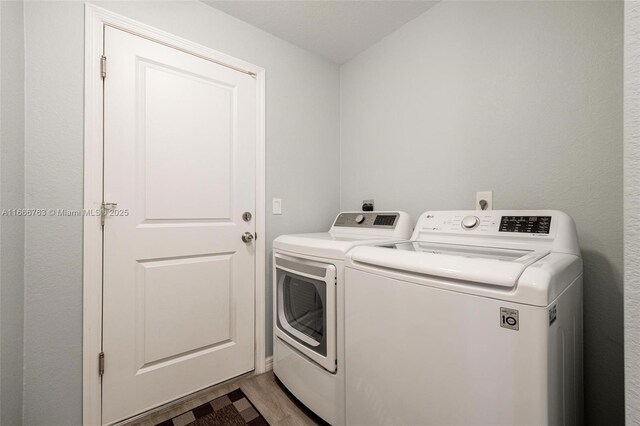 laundry room featuring light hardwood / wood-style floors and washing machine and clothes dryer