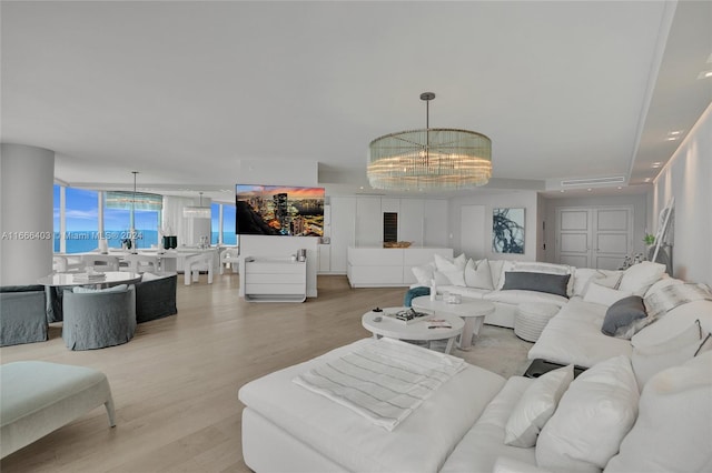 living room with a notable chandelier and light hardwood / wood-style flooring