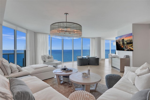 living room featuring a wealth of natural light, a water view, light wood-type flooring, and expansive windows