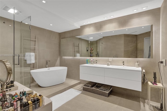 bathroom with a soaking tub, tile walls, double vanity, and a stall shower