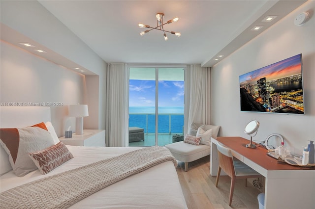 bedroom featuring access to outside, light hardwood / wood-style flooring, a chandelier, and expansive windows