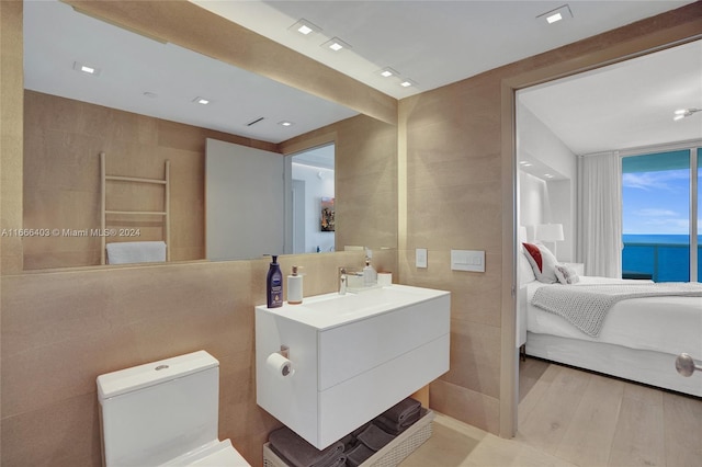 bathroom featuring vanity, tile walls, a water view, and hardwood / wood-style flooring