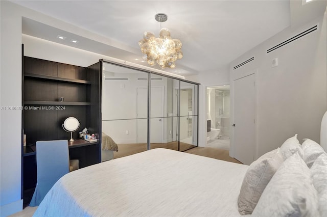 bedroom with a notable chandelier, visible vents, and connected bathroom