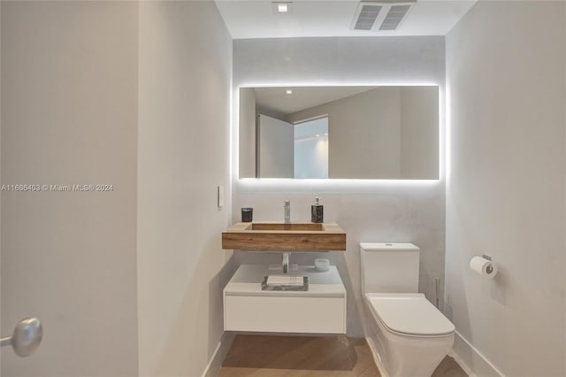 bathroom featuring sink, toilet, and hardwood / wood-style flooring