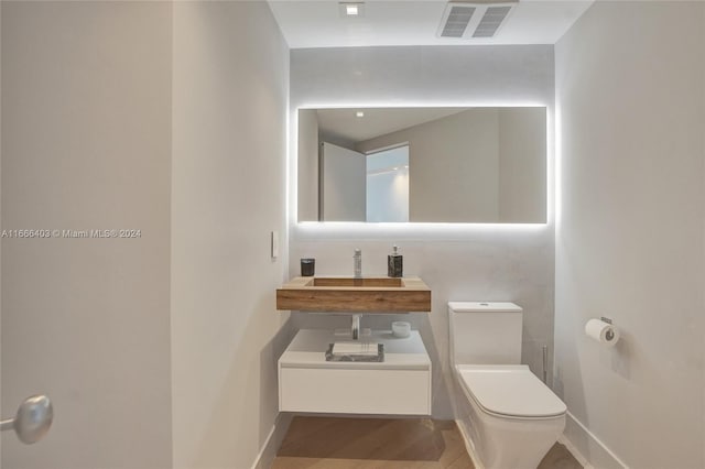 bathroom with toilet, baseboards, and visible vents
