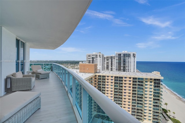 balcony featuring a view of the beach and a water view