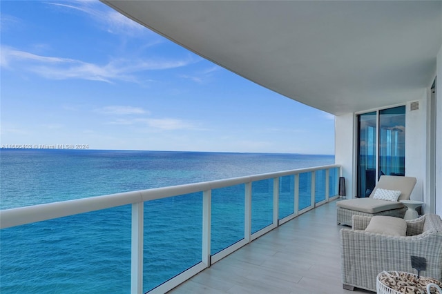 balcony featuring a water view and visible vents
