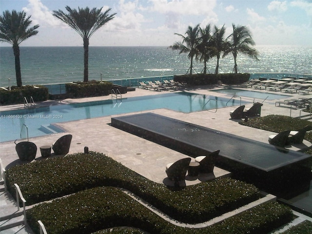 community pool with a water view and a patio