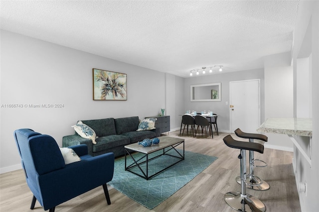 living room with light wood-type flooring and a textured ceiling