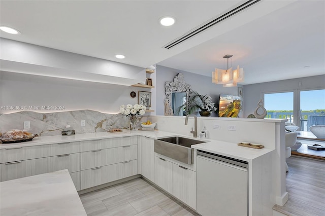 kitchen with sink, kitchen peninsula, decorative light fixtures, dishwasher, and light wood-type flooring