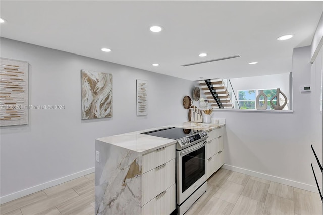 kitchen featuring kitchen peninsula, stainless steel electric range oven, and light stone counters