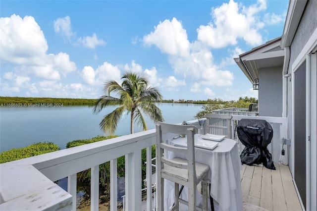 balcony with a water view and area for grilling