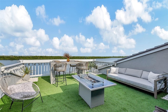 exterior space featuring a water view and an outdoor living space with a fire pit