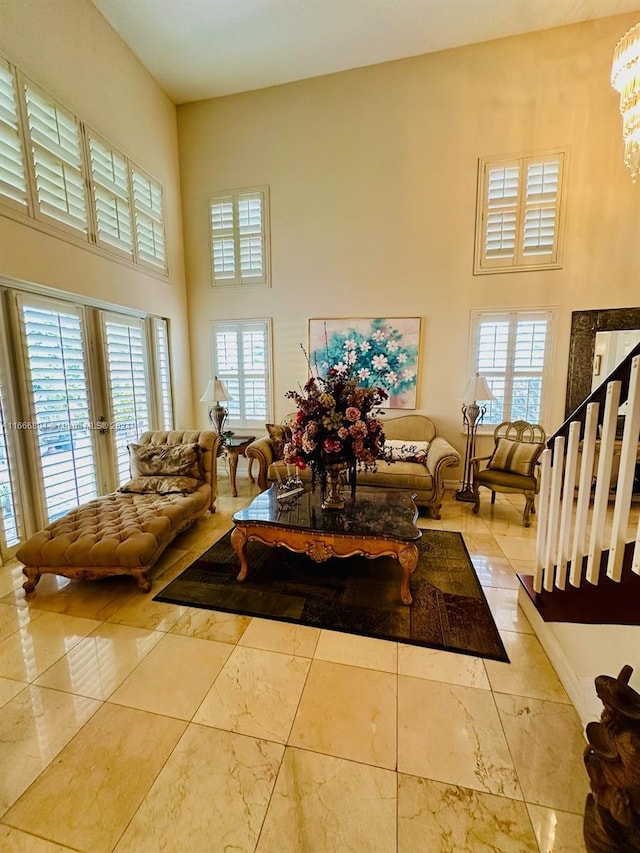 living room featuring french doors, a high ceiling, and a wealth of natural light