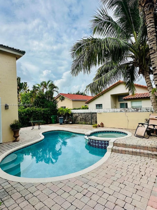 view of pool with a patio and an in ground hot tub