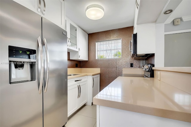2496 SW 17th Ave Unit 5307, Miami, FL 33145 - kitchen with stainless steel appliances, white cabinetry, glass insert cabinets, light countertops, and decorative backsplash
