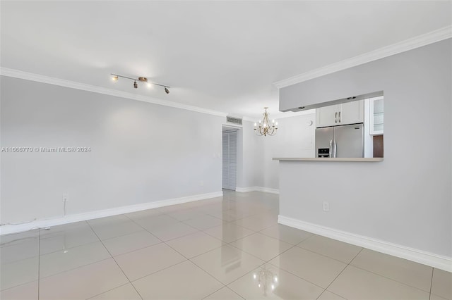 tiled empty room featuring crown molding and a chandelier