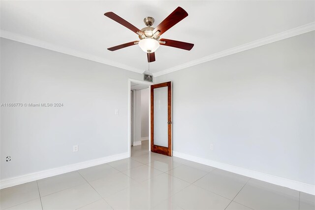 unfurnished room with ceiling fan, crown molding, and light tile patterned floors