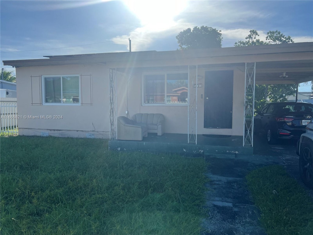 view of front of property featuring a front yard and a carport