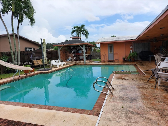 view of pool featuring a gazebo, a water slide, and a patio area