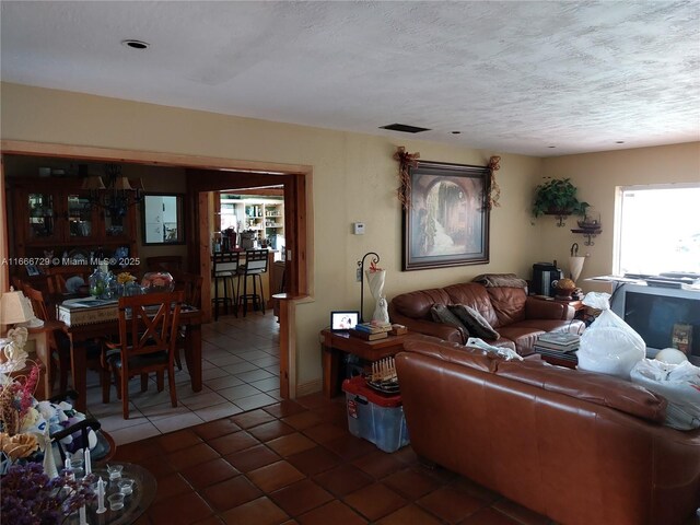 living room featuring a textured ceiling and dark tile patterned floors