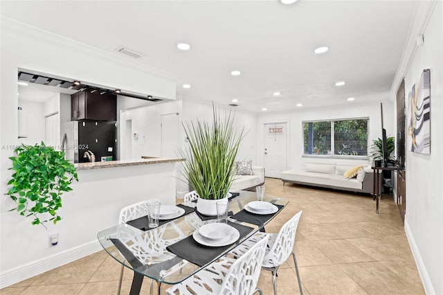 dining space with ornamental molding and light tile patterned flooring