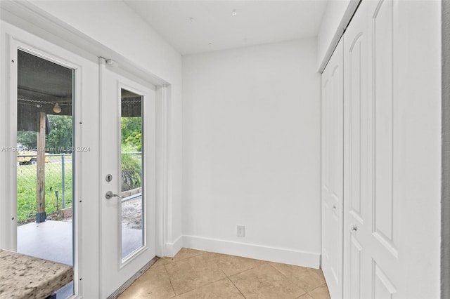 doorway to outside with light tile patterned flooring