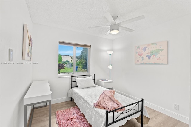 bedroom featuring a textured ceiling, hardwood / wood-style floors, and ceiling fan