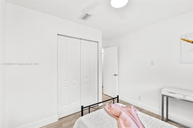 bedroom featuring ceiling fan, a closet, and light hardwood / wood-style flooring