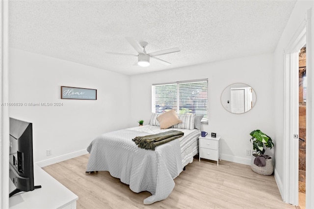 bedroom featuring ceiling fan, a textured ceiling, and light hardwood / wood-style floors