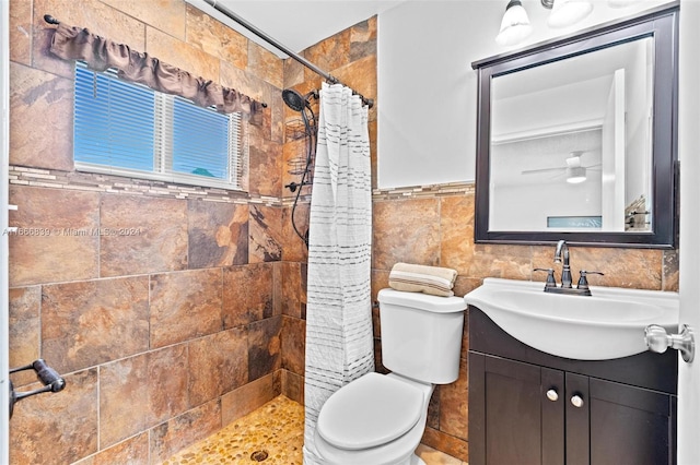 bathroom with tile walls, vanity, toilet, and a shower with curtain