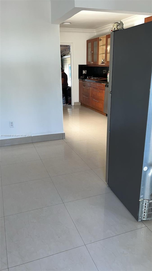 hallway with ornamental molding and light tile patterned floors