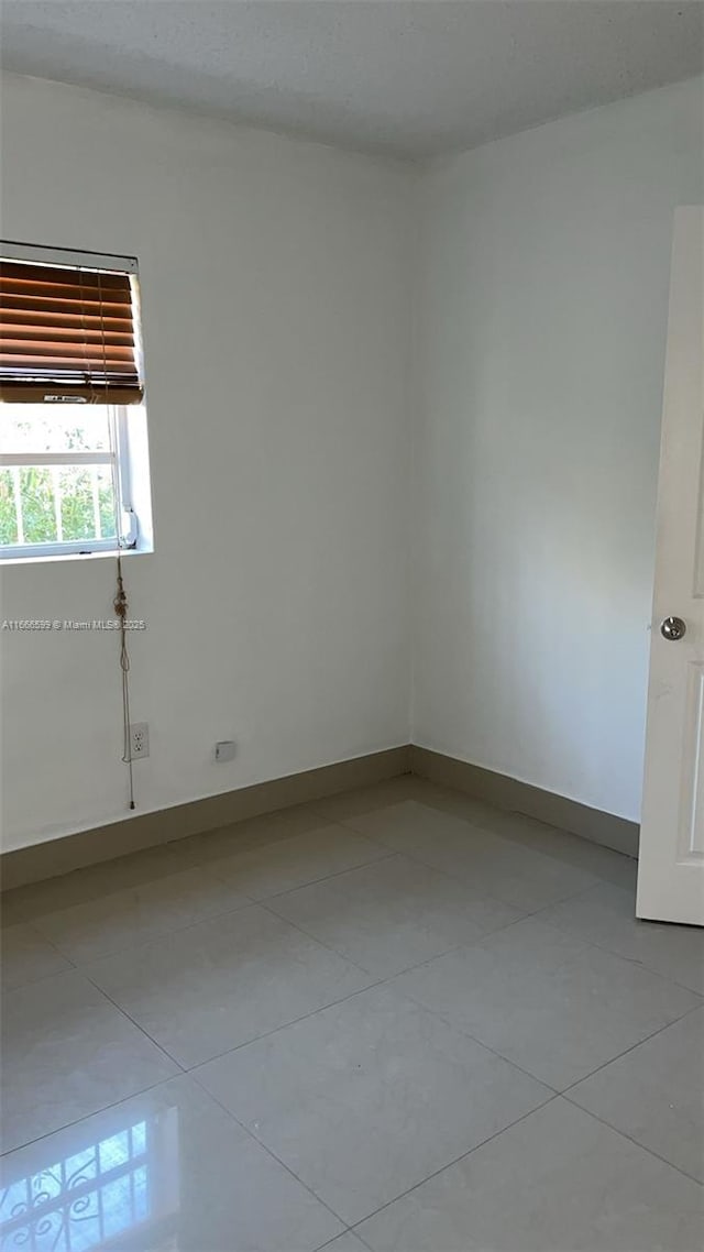 spare room featuring light tile patterned flooring