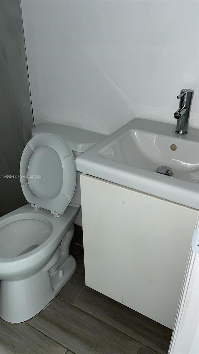 bathroom featuring vanity, hardwood / wood-style floors, and toilet