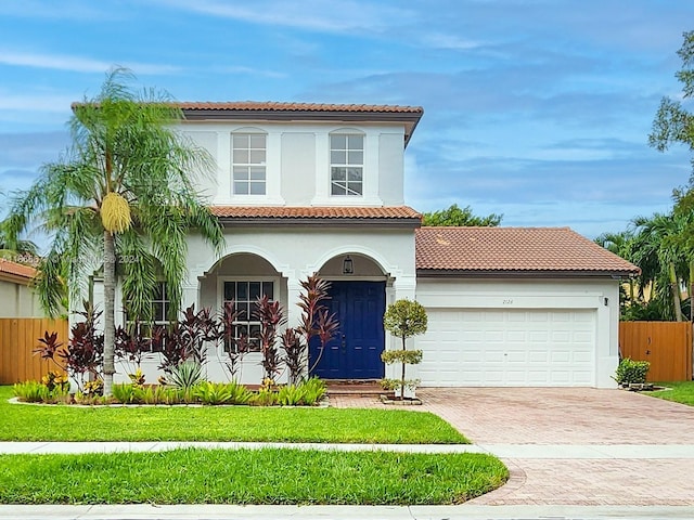 mediterranean / spanish-style house featuring a garage and a front lawn