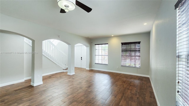 spare room with dark wood-type flooring and ceiling fan