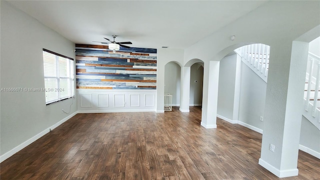 unfurnished living room with dark wood-type flooring and ceiling fan