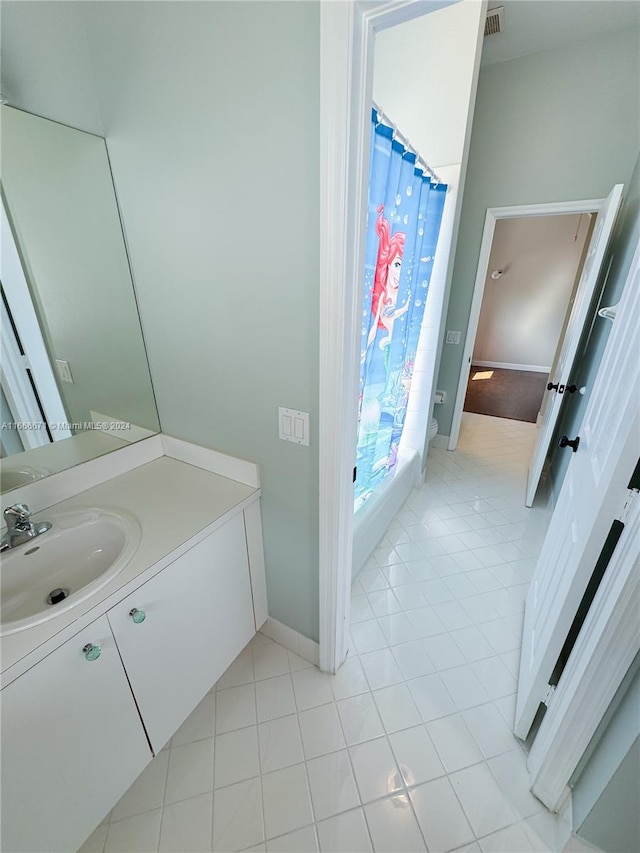 bathroom with a shower with curtain, vanity, and tile patterned floors