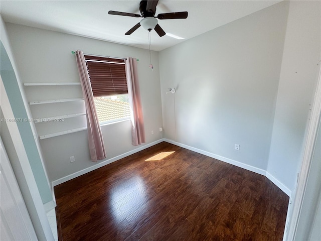 empty room with dark hardwood / wood-style flooring and ceiling fan