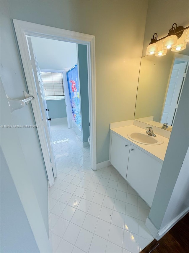 bathroom with walk in shower, vanity, and tile patterned floors