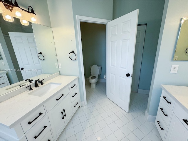 bathroom featuring vanity, tile patterned flooring, and toilet