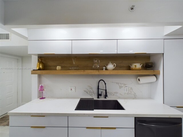 kitchen featuring sink, white cabinetry, dishwasher, light stone countertops, and decorative backsplash