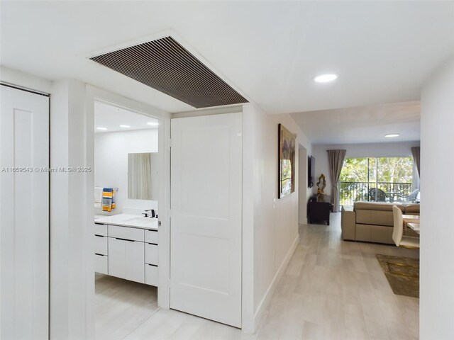 hall with sink and light hardwood / wood-style floors