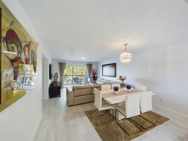 living room featuring a notable chandelier and light hardwood / wood-style flooring