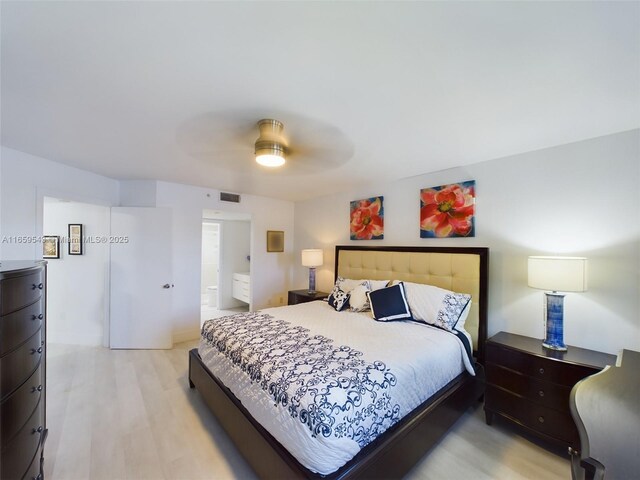 bedroom with ceiling fan, ensuite bath, and light hardwood / wood-style floors