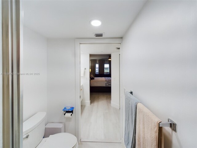 bathroom featuring wood-type flooring and toilet