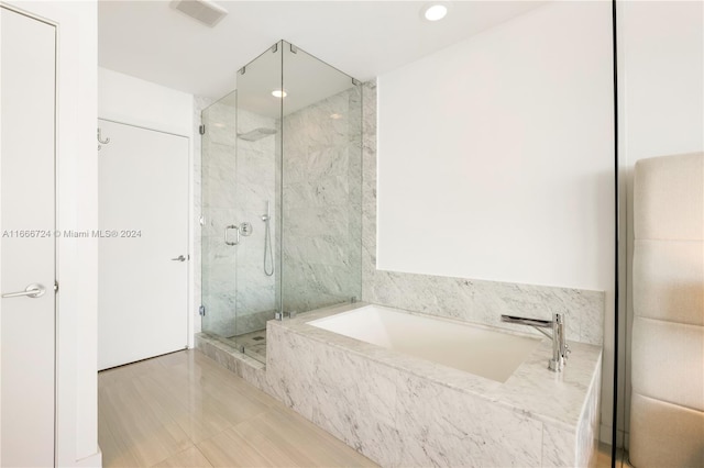 bathroom featuring tile patterned floors and separate shower and tub