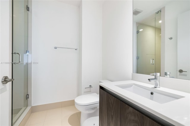 bathroom featuring vanity, tile patterned flooring, an enclosed shower, and toilet