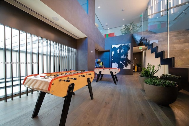 playroom with wood-type flooring and a high ceiling